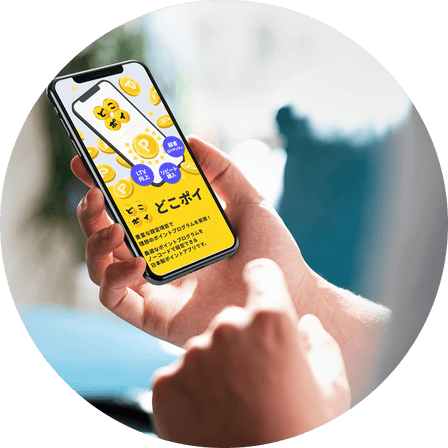 スマートフォンでポイントアプリ『どこポイ』を操作している手元。