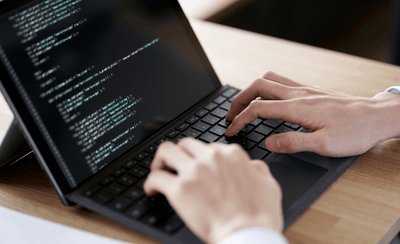 ノートパソコンでプログラミングをしている手元